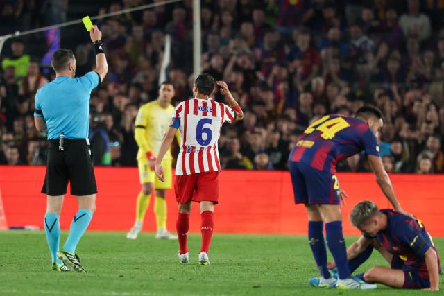 Atletico Madrid's Spanish midfielder #06 Koke (C) receives a yellow card from Romanian referee Istvan Kovacs during the UEFA Champions League quarter final first leg football match between FC Barcelona and Club Atletico de Madrid at Camp Nou Stadium in Barcelona on April 8, 2026. (Photo by Lluis GENE / AFP)