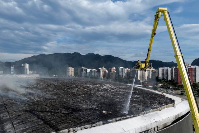 Firefighters work to extinguish a fire at the Olympic Velodrome in Rio de Janeiro, Brazil, on April 8, 2026. According to city authorities, the velodrome suffered limited damage and no injuries were reported, while the Rio Olympic Museum and its historical collection from the 2016 Olympic Games remained intact. (Photo by Pablo PORCIUNCULA / AFP)