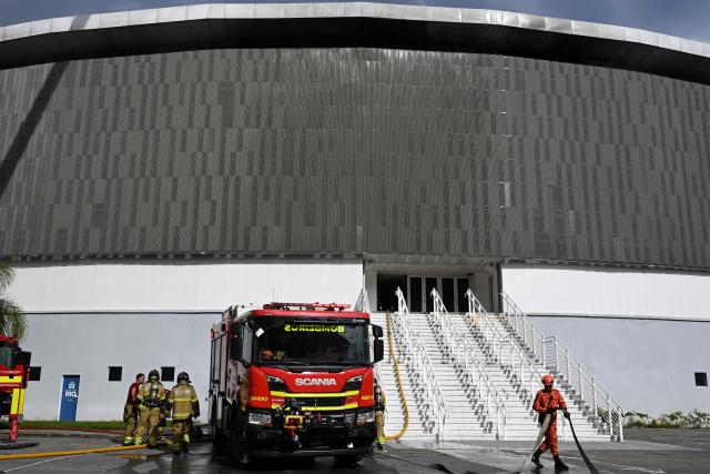 Firefighters work to extinguish a fire at the Olympic Velodrome in Rio de Janeiro, Brazil, on April 8, 2026. According to city authorities, the velodrome suffered limited damage and no injuries were reported, while the Rio Olympic Museum and its historical collection from the 2016 Olympic Games remained intact. (Photo by Pablo PORCIUNCULA / AFP)