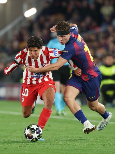 Atletico Madrid's Argentine forward #20 Giuliano Simeone (L) vies for the ball with Barcelona's Spanish midfielder #16 Fermin Lopez during the UEFA Champions League quarter final first leg football match between FC Barcelona and Club Atletico de Madrid at Camp Nou Stadium in Barcelona on April 8, 2026. (Photo by Lluis GENE / AFP)