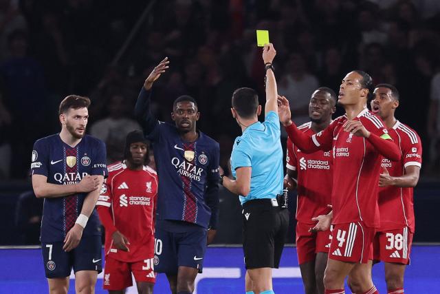 Spanish referee Jose Maria Sanchez shows a yellow card for a penalty then cancelled  during the UEFA Champions League quarter-final first leg football match between Paris Saint-Germain (PSG) and Liverpool FC at the Parc des Princes stadium in Paris on April 8, 2026. (Photo by FRANCK FIFE / AFP)