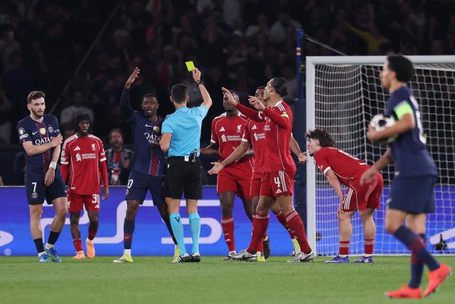 Spanish referee Jose Maria Sanchez shows a yellow card for a penalty then cancelled  during the UEFA Champions League quarter-final first leg football match between Paris Saint-Germain (PSG) and Liverpool FC at the Parc des Princes stadium in Paris on April 8, 2026. (Photo by FRANCK FIFE / AFP)