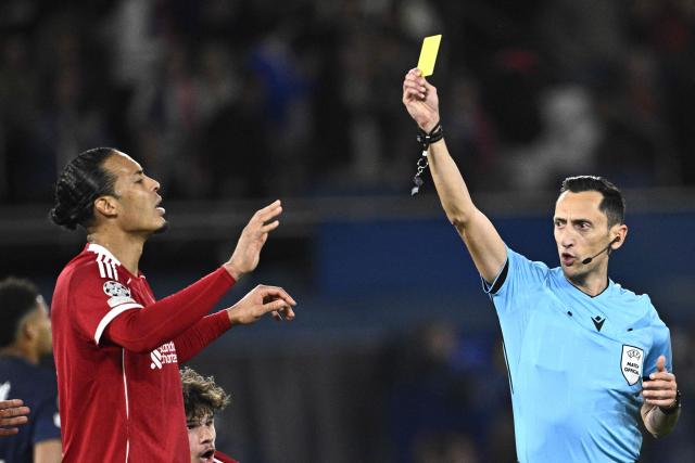 Liverpool's Dutch defender #04 Virgil van Dijk is shown a yellow card by Spanish referee Jose Maria Sanchez during the UEFA Champions League quarter-final first leg football match between Paris Saint-Germain (PSG) and Liverpool FC at the Parc des Princes stadium in Paris on April 8, 2026. (Photo by JULIEN DE ROSA / AFP)