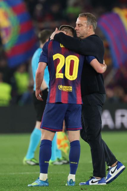 Barcelona's German coach Hans-Dieter Flick (R) embraces Barcelona's Spanish midfielder #20 Daniel Olmo after the UEFA Champions League quarter final first leg football match between FC Barcelona and Club Atletico de Madrid at Camp Nou Stadium in Barcelona on April 8, 2026. (Photo by Lluis GENE / AFP)