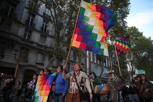 Demonstrators wave Wiphala flags as they march during a protest against the modifications in glacier law in Buenos Aires on April 8, 2026. Argentine deputies will debate on April 8, 2026 a government proposal calling on the provinces to redefine glacier protection zones in order to expand mining operations. (Photo by TOMAS CUESTA / AFP)