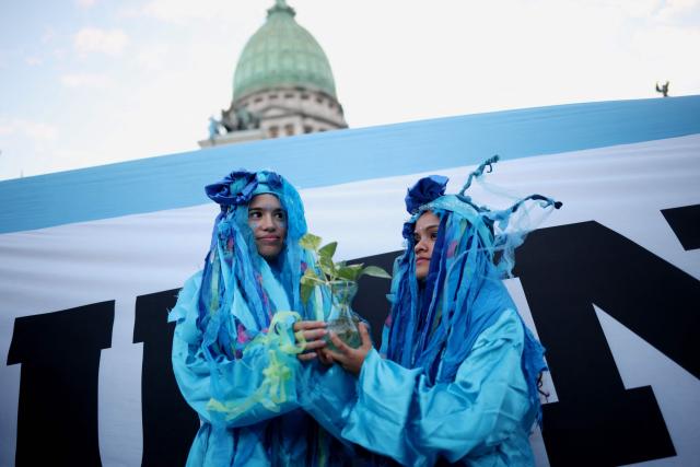 Demonstrators wearing costumes take part in a protest against the modifications in glacier law in front of the Congress building in Buenos Aires on April 8, 2026. Argentine deputies will debate on April 8, 2026 a government proposal calling on the provinces to redefine glacier protection zones in order to expand mining operations. (Photo by TOMAS CUESTA / AFP)