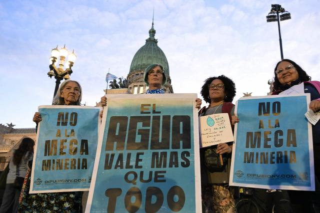 Demonstrators pose during a protest against the modifications of the Glaciers Law in front of the Congress building in Buenos Aires, on April 8, 2026. Argentine deputies are debating a government proposal calling on the provinces to redefine glacier protection zones in order to expand mining operations. (Photo by JUAN MABROMATA / AFP)