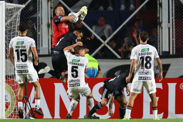 Palestino's goalkeeper #25 Sebastian Perez, Deportivo Riestra's defender #05 Pedro Ramirez and Palestino's Argentine midfielder #05 Julian Fernandez fight for the ball during the Copa Sudamericana group stage football match between Argentina's Deportivo Riestra and Chile's Palestino at the Pedro Bidegain stadium in Buenos Aires on April 8, 2026. (Photo by ALEJANDRO PAGNI / AFP)