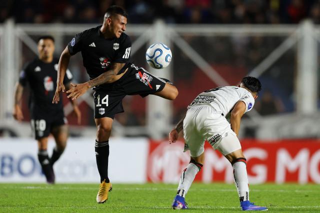 Deportivo Riestra's midfielder #14 Pablo Daniel Monje and Palestino's midfielder #08 Nicolas Meza fight for the ball during the Copa Sudamericana group stage football match between Argentina's Deportivo Riestra and Chile's Palestino at the Pedro Bidegain stadium in Buenos Aires on April 8, 2026. (Photo by ALEJANDRO PAGNI / AFP)