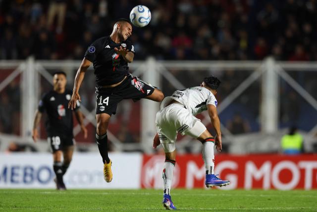 Deportivo Riestra's midfielder #14 Pablo Daniel Monje and Palestino's midfielder #08 Nicolas Meza fight for the ball during the Copa Sudamericana group stage football match between Argentina's Deportivo Riestra and Chile's Palestino at the Pedro Bidegain stadium in Buenos Aires on April 8, 2026. (Photo by ALEJANDRO PAGNI / AFP)