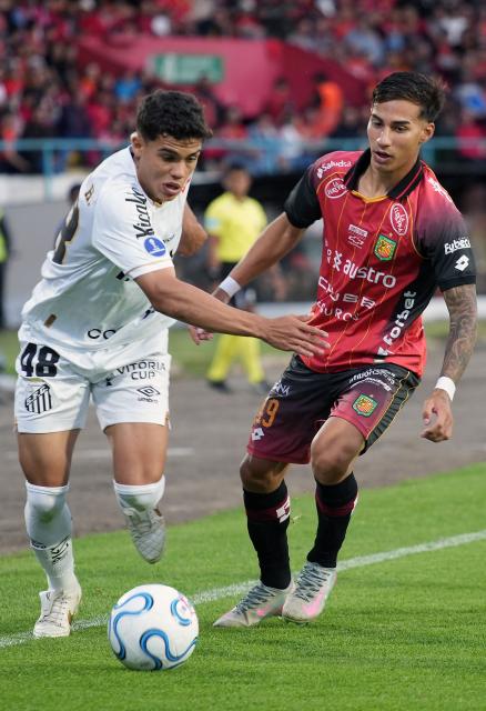 Santos' midfielder #48 Gustavo Henrique and Deportivo Cuenca's Argentine midfielder #49 David Gonzalez fight for the ball during the Copa Sudamericana group stage football match between Ecuador's Deportivo Cuenca and Brazil's Santos at the Alejandro Serrano Aguilar stadium in Cuenca, Ecuador, on April 8, 2026. (Photo by Fernando MACHADO / AFP)
