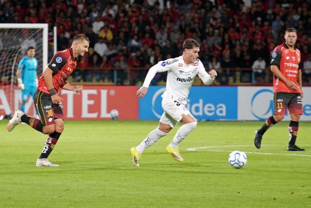 Santos' Argentine midfielder #32 Benjamin Rollheiser controls the ball amid Deportivo Cuenca's Argentine midfielder #30 Mateo Maccari and Deportivo Cuenca's Argentine forward #11 German Rivero during the Copa Sudamericana group stage football match between Ecuador's Deportivo Cuenca and Brazil's Santos at the Alejandro Serrano Aguilar stadium in Cuenca, Ecuador, on April 8, 2026. (Photo by Fernando MACHADO / AFP)
