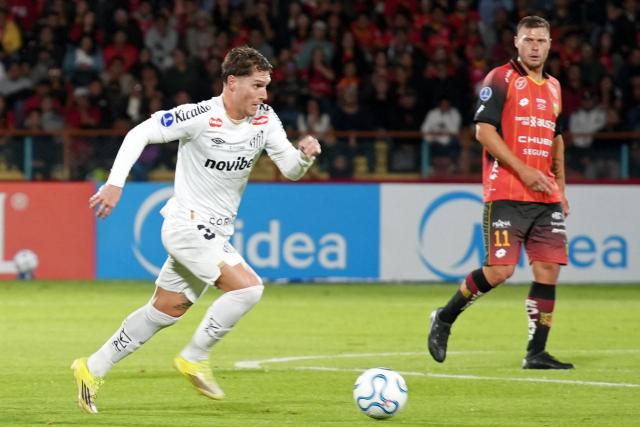 Santos' Argentine midfielder #32 Benjamin Rollheiser controls the ball past Deportivo Cuenca's Argentine forward #11 German Rivero during the Copa Sudamericana group stage football match between Ecuador's Deportivo Cuenca and Brazil's Santos at the Alejandro Serrano Aguilar stadium in Cuenca, Ecuador, on April 8, 2026. (Photo by Fernando MACHADO / AFP)