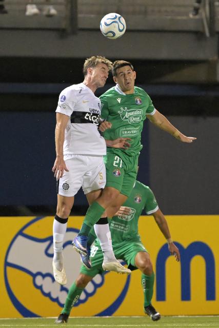 Olimpia's Argentine midfielder #05 Juan Alfaro and Audax Italiano's forward #27 Michael Vadulli fight for the ball during the Copa Sudamericana group stage football match between Chile's Audax Italiano and Paraguay's Olimpia at the Bicentenario de la Florida stadium in Santiago on April 8, 2026. (Photo by Rodrigo ARANGUA / AFP)
