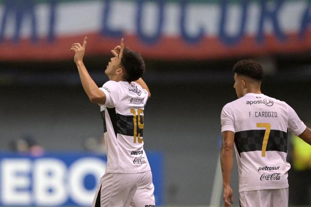 Olimpia's midfielder #19 Ruben Lezcano celebrates next to teammate forward #07 Fernando Cardozo after scoring the opening goal during the Copa Sudamericana group stage football match between Chile's Audax Italiano and Paraguay's Olimpia at the Bicentenario de la Florida stadium in Santiago on April 8, 2026. (Photo by Rodrigo ARANGUA / AFP)