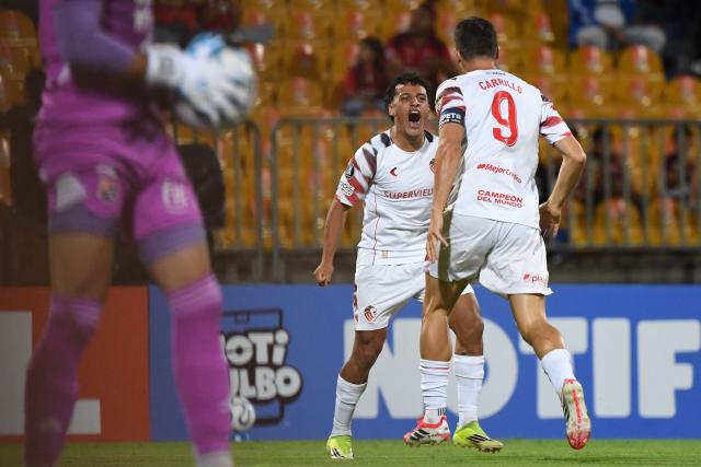 Estudiantes' Uruguayan forward #10 Tiago Palacios (L) celebrates with teammate forward #09 Guido Carrillo after scoring his team's first goal during the Copa Libertadores group stage football match between Colombia's Independiente Medellin and Argentina's Estudiantes de La Plata at the Atanasio Girardot stadium in Medellin, Antioquia department, Colombia, on April 8, 2026. (Photo by Jaime SALDARRIAGA / AFP)