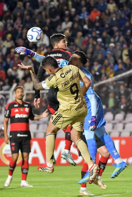 Flamengo's Argentine goalkeeper #01 Agustin Rossi clears the ball away from Cusco's Argentine forward #09 Facundo Callejo during the Copa Libertadores group stage football match between Peru's Cusco FC and Brazil's Flamengo at the Inca Garcilaso de la Vega stadium in Cusco, Peru, on April 8, 2026. (Photo by Diego RAMOS / AFP)