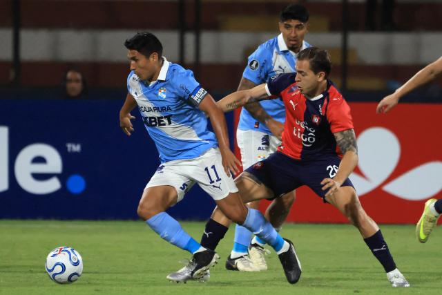 Sporting Cristal's forward #11 Irven Avila and Cerro Porteno's defender #23 Gustavo Velazquez fight for the ball during the Copa Libertadores group stage football match between Peru's Sporting Cristal and Paraguay's Cerro Porteno at the Nacional stadium in Lima, on April 8, 2026. (Photo by Connie FRANCE / AFP)