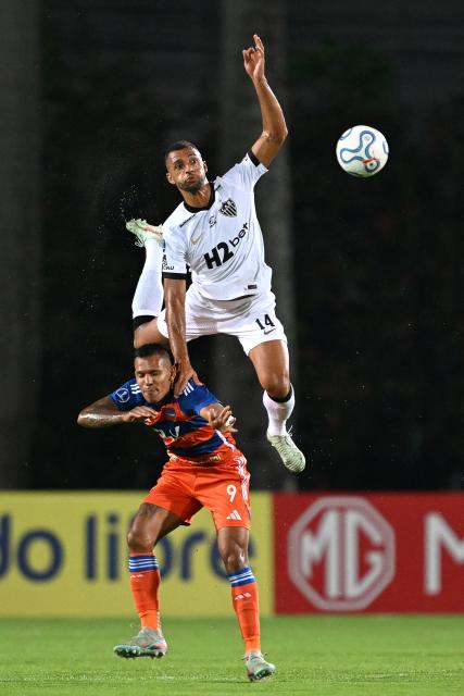 Atletico Mineiro's defender #14 Vitor Hugo and Puerto Cabello's forward #09 Andres Ponce fight for the ball during the Copa Sudamericana group stage football match between Venezuela's Academia Puerto Cabello and Brazil's Atletico Mineiro at the Misael Delgado stadium in Valencia, state of Carabobo, Venezuela, on April 8, 2026. (Photo by Juan BARRETO / AFP)