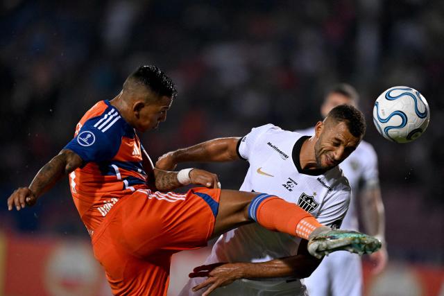 Puerto Cabello's forward #09 Andres Poncea and Atletico Mineiro's defender #14 Vitor Hugo fight for the ball during the Copa Sudamericana group stage football match between Venezuela's Academia Puerto Cabello and Brazil's Atletico Mineiro at the Misael Delgado stadium in Valencia, state of Carabobo, Venezuela, on April 8, 2026. (Photo by Juan BARRETO / AFP)