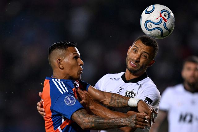 Puerto Cabello's forward #09 Andres Poncea and Atletico Mineiro's defender #14 Vitor Hugo fight for the ball during the Copa Sudamericana group stage football match between Venezuela's Academia Puerto Cabello and Brazil's Atletico Mineiro at the Misael Delgado stadium in Valencia, state of Carabobo, Venezuela, on April 8, 2026. (Photo by Juan BARRETO / AFP)