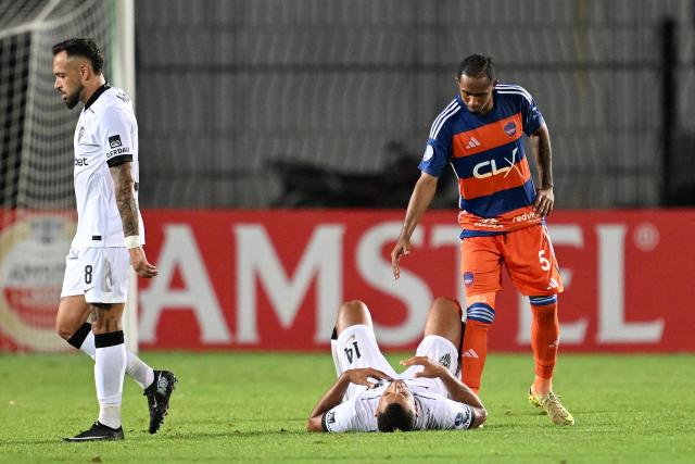 Puerto Cabello's midfielder #05 Gustavo Gonzalez comforts Atletico Mineiro's defender #14 Vitor Hugo after the Copa Sudamericana group stage football match between Venezuela's Academia Puerto Cabello and Brazil's Atletico Mineiro at the Misael Delgado stadium in Valencia, state of Carabobo, Venezuela, on April 8, 2026. (Photo by Juan BARRETO / AFP)