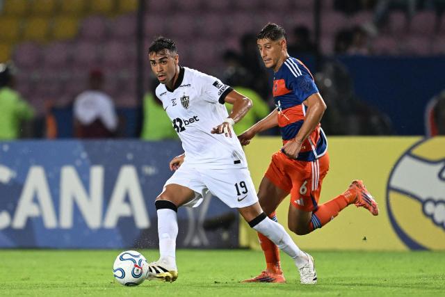 Atletico Mineiro's midfielder #19 Reinier kicks the ball past Puerto Cabello's Uruguayan midfielder #06 Pablo Lima during the Copa Sudamericana group stage football match between Venezuela's Academia Puerto Cabello and Brazil's Atletico Mineiro at the Misael Delgado stadium in Valencia, state of Carabobo, Venezuela, on April 8, 2026. (Photo by Juan BARRETO / AFP)