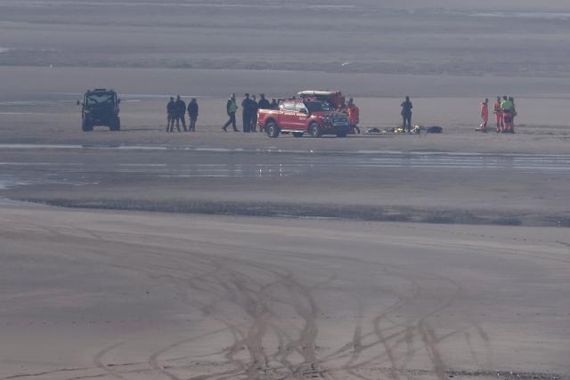 Rescue vehicles and medical units gather on the beach to treat victims after an attempt to cross the English Channel illegally turned tragic with several migrants found in cardiac arrest, in France's Pas-de-Calais northern coastal city of Equihen-Plage on April 9, 2026. (Photo by Sameer AL-DOUMY / AFP)