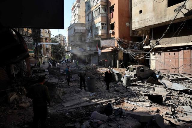 TOPSHOT - This picture taken on April 9, 2026, shows people inspecting the site of the previos day's Israeli airstrikes that targeted the Shiah area in the southern suburbs of Beirut. The Israeli military said it struck a Hezbollah commander in Beirut on April 8, after Lebanese state media reported that Israel had targeted a residential neighbourhood in the capital. (Photo by Anwar AMRO / AFP)