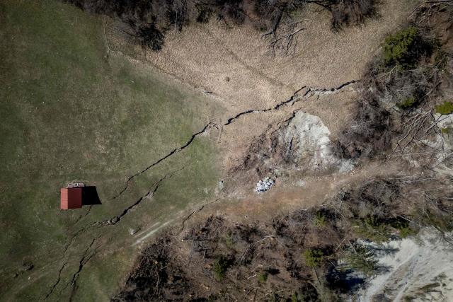 This aerial photograph shows the Fios fault line near Vissoie in the Val d’Anniviers, canton of Valais, southwestern Switzerland on April 8, 2026. The fracture is gradually widening, raising fears of a partial mountainside collapse that could block the river below and trigger flooding downstream. Authorities are monitoring the site and preparing safety and evacuation plans for the village of Chippis at the bottom of the valley. (Photo by Fabrice COFFRINI / AFP)