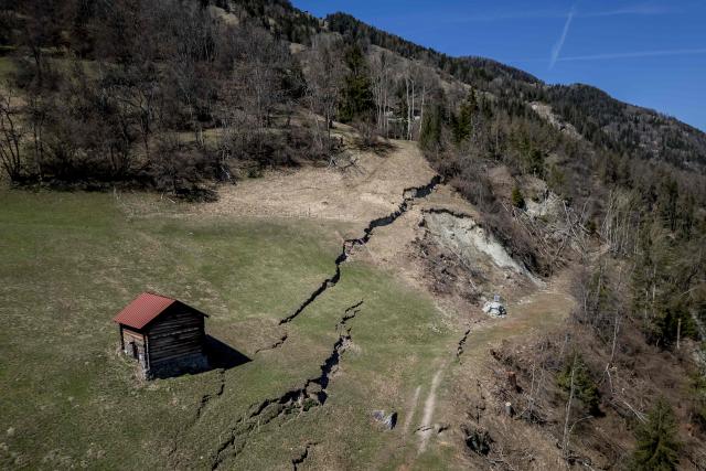 This aerial photograph shows the Fios fault line near Vissoie in the Val d’Anniviers, canton of Valais, southwestern Switzerland on April 8, 2026. The fracture is gradually widening, raising fears of a partial mountainside collapse that could block the river below and trigger flooding downstream. Authorities are monitoring the site and preparing safety and evacuation plans for the village of Chippis at the bottom of the valley. (Photo by Fabrice COFFRINI / AFP)