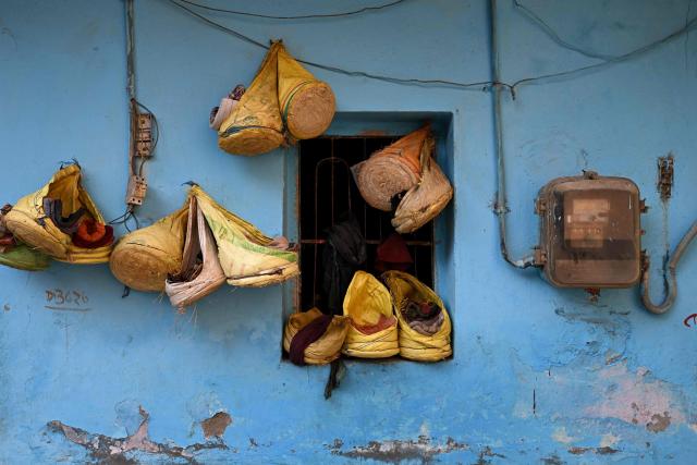 Head cushions of migrant workers are seen hanged on a wall in New Delhi on April 9, 2026. (Photo by Sajjad HUSSAIN / AFP)