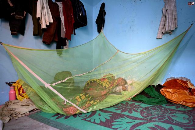 A migrant worker sleeps inside a mosquito net at his rented room in New Delhi on April 9, 2026. (Photo by Sajjad HUSSAIN / AFP)
