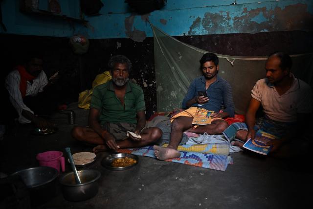 Migrant workers sit inside their rented room in New Delhi on April 9, 2026. (Photo by Sajjad HUSSAIN / AFP)