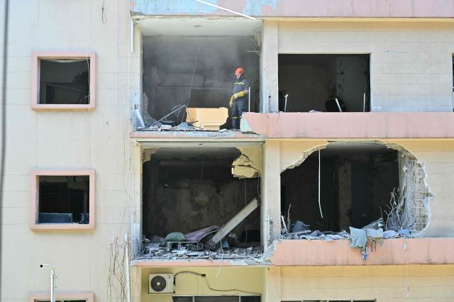 A first responder inspects the site of the previous day's Israeli airstrike that targeted a building in Beirut's al-Manara neighbourhood on April 9, 2026. The Israeli military said it struck a Hezbollah commander in Beirut on April 8, after Lebanese state media reported that Israel had targeted a residential neighbourhood in the capital. (Photo by FADEL itani / AFP)