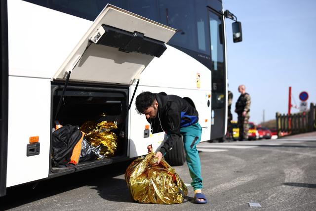 A man packs his belongings before boarding a bus to a reception and accommodation centre after an attempt to cross the English Channel illegally turned tragic with several migrants found in cardiac arrest, in France's Pas-de-Calais northern coastal city of Equihen-Plage on April 9, 2026. Two men and two women died on April 9, 2026 morning whilst attempting to cross the English Channel illegally; they were ‘swept away’ by the currents off the coast of Equihen-Plage (Pas-de-Calais), announced Franзois-Xavier Lauch, the Prefect of Pas-de-Calais, at the scene. (Photo by Sameer AL-DOUMY / AFP)