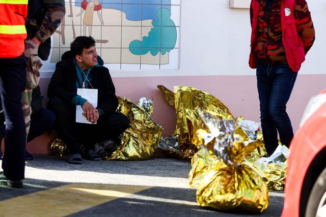 A man sits next to rescue units after an attempt to cross the English Channel illegally turned tragic with several migrants found in cardiac arrest, in France's Pas-de-Calais northern coastal city of Equihen-Plage on April 9, 2026. Two men and two women died on April 9, 2026 morning whilst attempting to cross the English Channel illegally; they were ‘swept away’ by the currents off the coast of Equihen-Plage (Pas-de-Calais), announced Franзois-Xavier Lauch, the Prefect of Pas-de-Calais, at the scene. (Photo by Sameer AL-DOUMY / AFP)