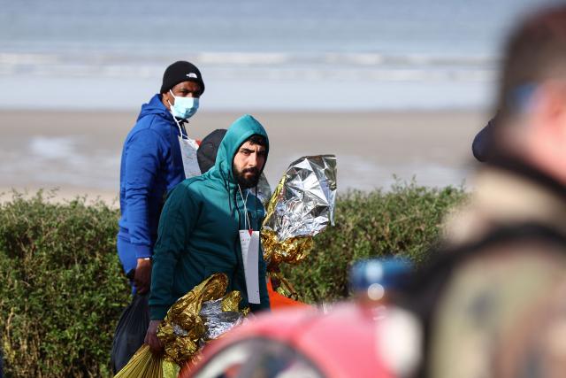Men look on after an attempt to cross the English Channel illegally turned tragic with several migrants found in cardiac arrest, in France's Pas-de-Calais northern coastal city of Equihen-Plage on April 9, 2026. Two men and two women died on April 9, 2026 morning whilst attempting to cross the English Channel illegally; they were ‘swept away’ by the currents off the coast of Equihen-Plage (Pas-de-Calais), announced Franзois-Xavier Lauch, the Prefect of Pas-de-Calais, at the scene. (Photo by Sameer AL-DOUMY / AFP)