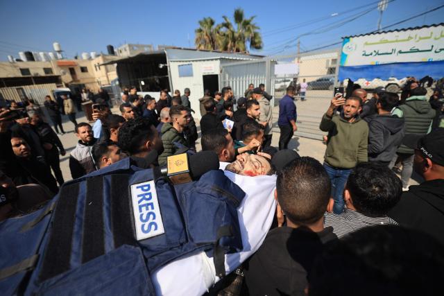 EDITORS NOTE: Graphic content / Mourners carry the body of Al Jazeera journalist Mohammad Wishah, who was killed in an Israeli strike, during his funeral at at the Al-Aqsa Martyrs Hospital in Deir al-Balah in the central Gaza Strip, on April 9, 2026. Al Jazeera reported on April 8 that one of its journalists, Mohammed Washeha, was killed when an Israeli drone strike targeted his car in Gaza. “Al Jazeera correspondent Mohammed Washeha was martyred in the Gaza Strip after an Israeli drone targeted his car,” the channel said. (Photo by Eyad Baba / AFP)