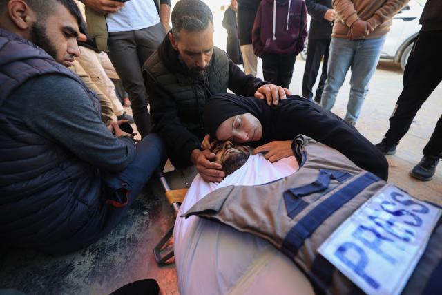 EDITORS NOTE: Graphic content / TOPSHOT - The sister of Al Jazeera journalist Mohammad Wishah, who was killed in an Israeli strike, mourns over his body during his funeral at the Al-Aqsa Martyrs Hospital in Deir al-Balah in the central Gaza Strip, on April 9, 2026. Al Jazeera reported on April 8 that one of its journalists, Mohammed Wishah, was killed when an Israeli drone strike targeted his car in Gaza. “Al Jazeera correspondent Mohammed Wishah was martyred in the Gaza Strip after an Israeli drone targeted his car,” the channel said. (Photo by Eyad Baba / AFP)
