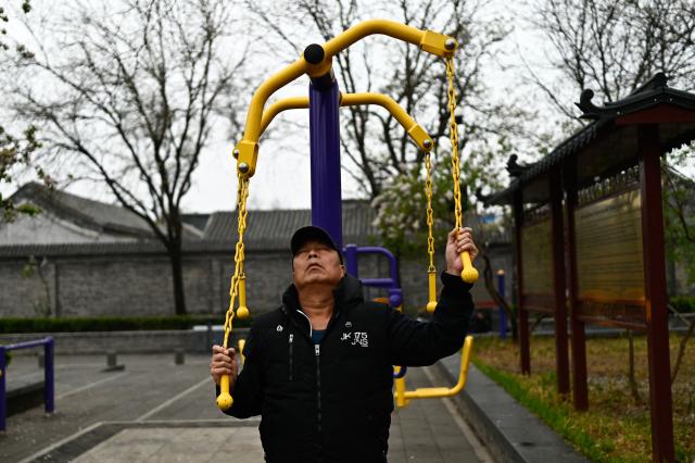 A man exercises in a public park in Beijing on April 9, 2026. (Photo by Pedro PARDO / AFP)