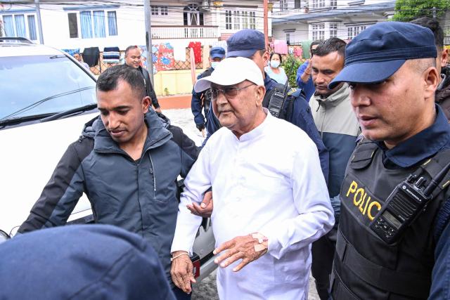 (FILES) Nepal's former prime minister KP Sharma Oli (C) is escorted by police as he is brought to the hospital following his arrest in Kathmandu on March 28, 2026. Nepal's ex-prime minister KP Sharma Oli and former interior minister Ramesh Lekhak have been released from custody after questioning for their alleged role in a deadly 2025 crackdown on protesters, police said on April 9. (Photo by Prakash MATHEMA / AFP)