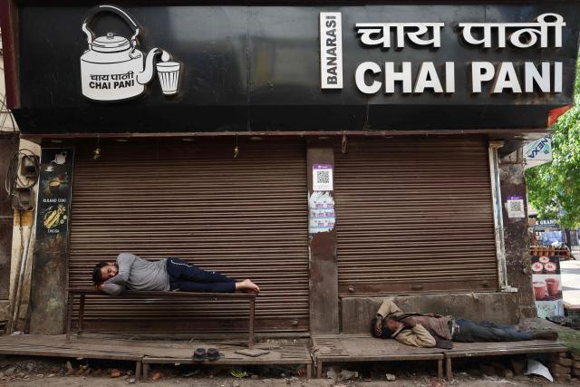 People sleep outside a closed shop in Varanasi on April 9, 2026. (Photo by Niharika KULKARNI / AFP)