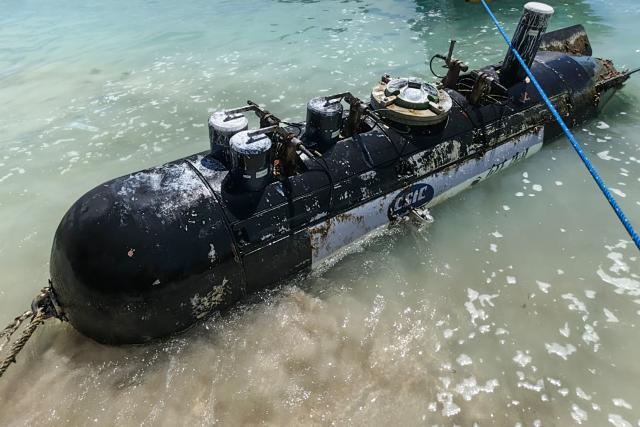 A picture taken on April 6, 2026, shows a torpedo-like 3.7-metre-long and 65-centimetre-wide object, discovered by a fisherman near the Lombok Strait after being towed ashore onto a beach on Gili Trawangan, West Nusa Tenggara. The Indonesian navy said on April 9, it was investigating a torpedo-like object discovered by a fisherman near the Lombok Strait, a key maritime route connecting the Indian and Pacific Oceans. (Photo by AFP)