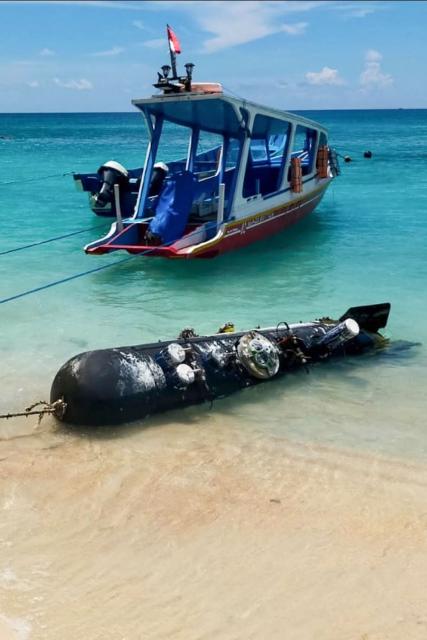 A picture taken on April 6, 2026, shows a torpedo-like 3.7-metre-long and 65-centimetre-wide object, discovered by a fisherman near the Lombok Strait after being towed ashore onto a beach on Gili Trawangan, West Nusa Tenggara. The Indonesian navy said on April 9, it was investigating a torpedo-like object discovered by a fisherman near the Lombok Strait, a key maritime route connecting the Indian and Pacific Oceans. (Photo by AFP)