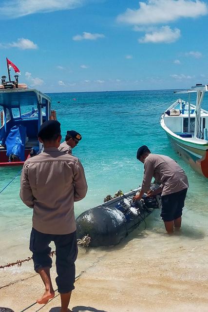 A picture taken on April 6, 2026, shows a torpedo-like 3.7-metre-long and 65-centimetre-wide object, discovered by a fisherman near the Lombok Strait after being towed ashore onto a beach on Gili Trawangan, West Nusa Tenggara. The Indonesian navy said on April 9, it was investigating a torpedo-like object discovered by a fisherman near the Lombok Strait, a key maritime route connecting the Indian and Pacific Oceans. (Photo by AFP)