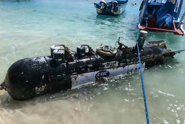 A picture taken on April 6, 2026, shows a torpedo-like 3.7-metre-long and 65-centimetre-wide object, discovered by a fisherman near the Lombok Strait after being towed ashore onto a beach on Gili Trawangan, West Nusa Tenggara. The Indonesian navy said on April 9, it was investigating a torpedo-like object discovered by a fisherman near the Lombok Strait, a key maritime route connecting the Indian and Pacific Oceans. (Photo by AFP)