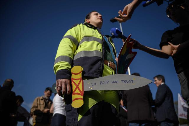 An employee of paper pulp producer Fibre Excellence talks to journalists outside the group's Saint-Gaudens site during a rally as the company faces a potential receivership, in Saint-Gaudens, south western France on April 9, 2026. The Fibre Excellence group, which employs 670 people, 275 in Saint-Gaudens and 270 in Tarascon, produces 500,000 tonnes annually out of the two million tonnes of paper pulp consumed in France. It is owned by Jackson Wijaya, whose family runs the Indonesian global paper giant Asia Pulp and Paper. (Photo by Ed JONES / AFP)