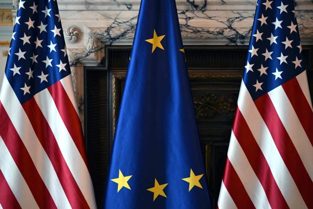 This photograph shows two flags of the United States and a flag of the European Union during an interview at US embassy in Brussels on April 9, 2026. (Photo by Nicolas TUCAT / AFP)