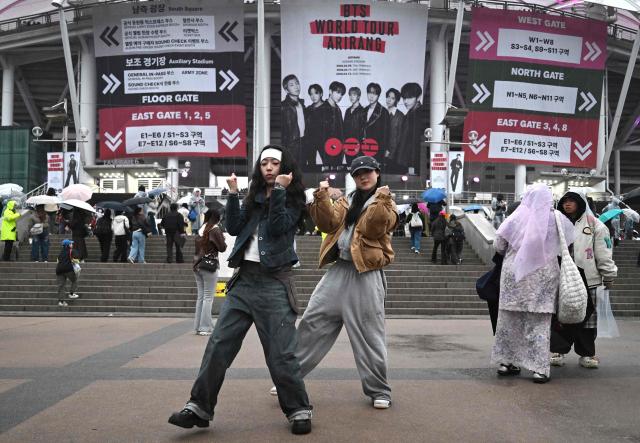 BTS fans dance outside a stadium where K-pop boy band BTS will perform in Goyang on April 9, 2026. South Korean K-pop megastars BTS kicked off their world tour on April 9, riding the momentum of a chart-topping comeback album and a landmark performance in the heart of Seoul. (Photo by Jung Yeon-je / AFP)